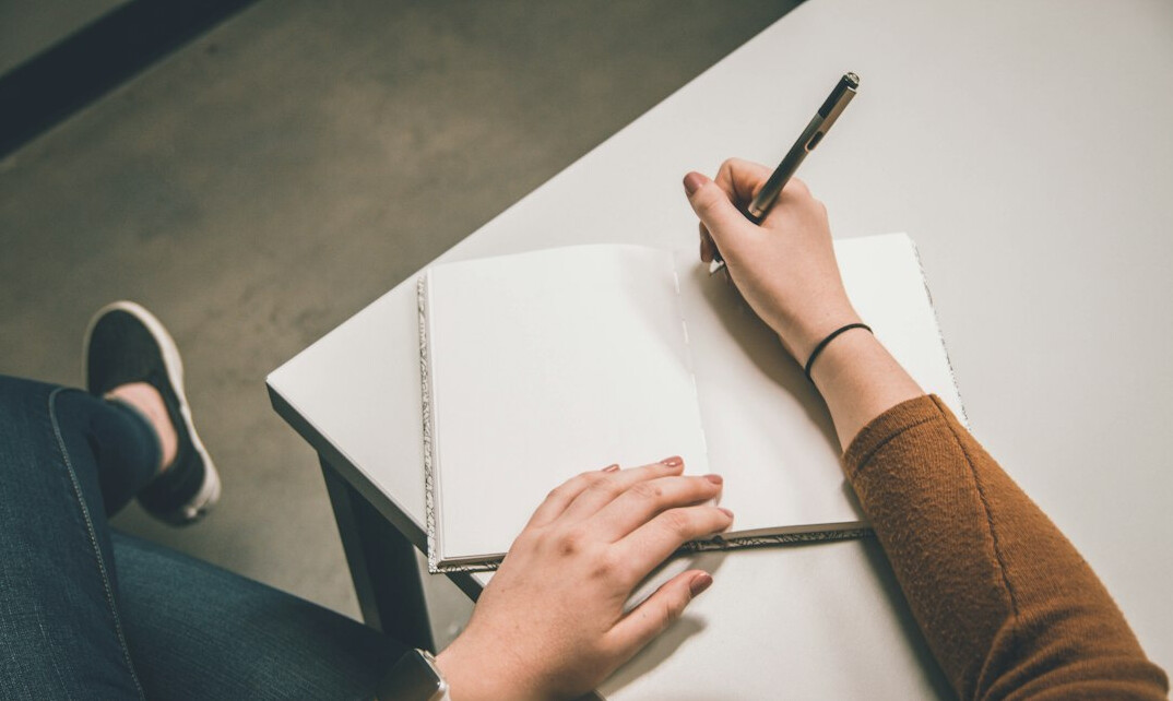 person writing in journal